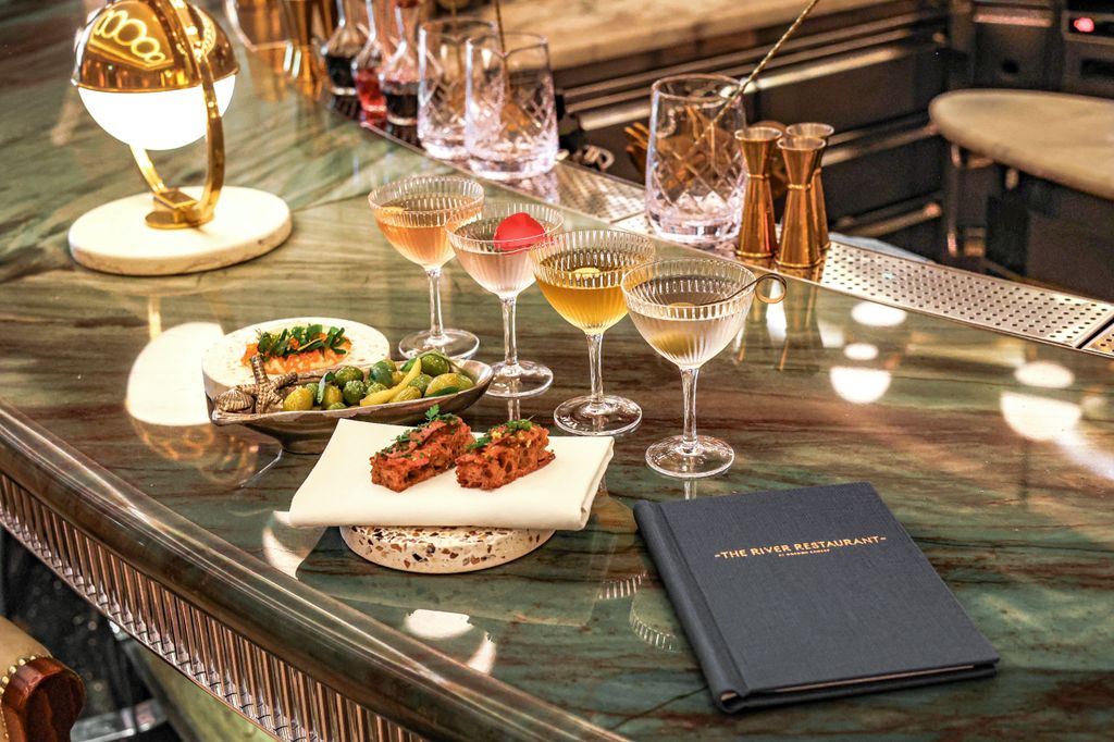 bar with four martini glasses, menu and bar snacks