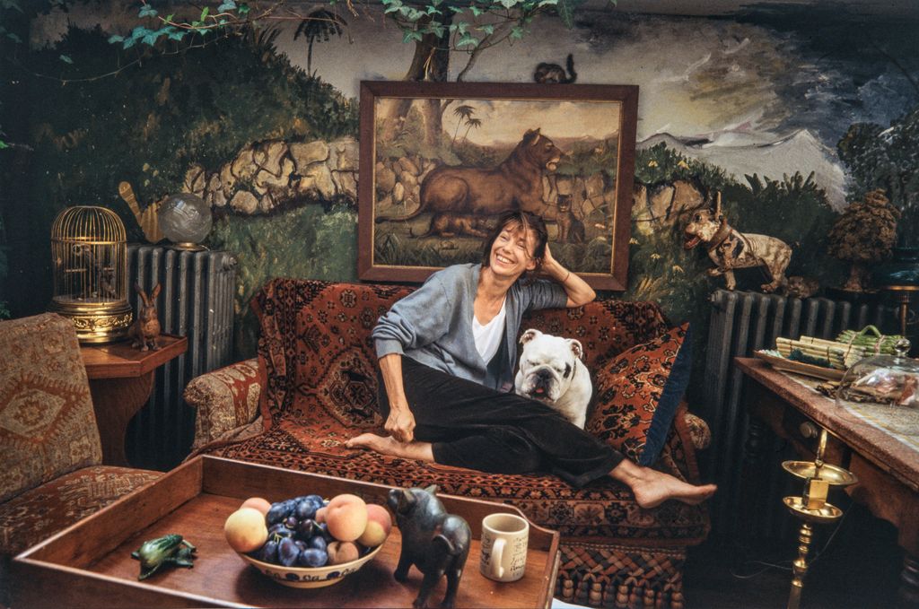 Jane Birkin poses barefoot on a sofa covered with an oriental woven carpet with her British Bulldog Dora by her side in the salon of her former home in the Rue Jacob, Paris, 16th arrondissement, January 2001