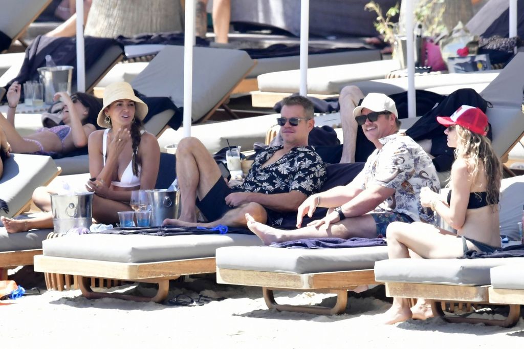 Matt Damon and his wife Luciana Barroso sit on sun lounger with Luke Hemsworth and his wife Samantha