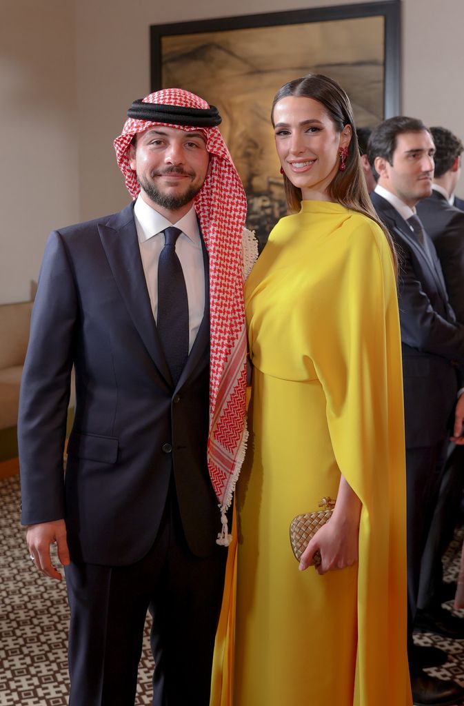 Crown Prince Hussein in a suit and turban and Princess Rajwa in a yellow dress