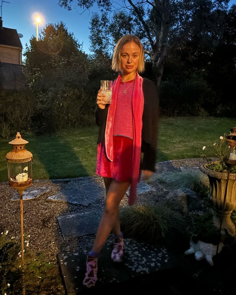 Amelia Windsor dalam balutan mini dress beludru pink dengan minuman