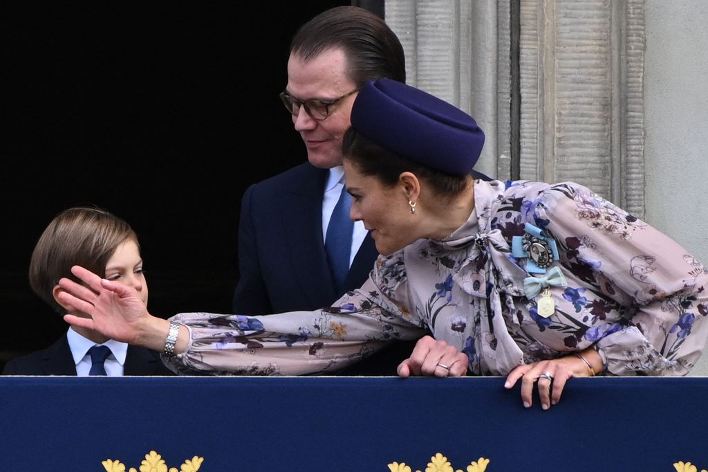 Crown Princess Victoria fixes the hair of Prince Oscar during their balcony appearance