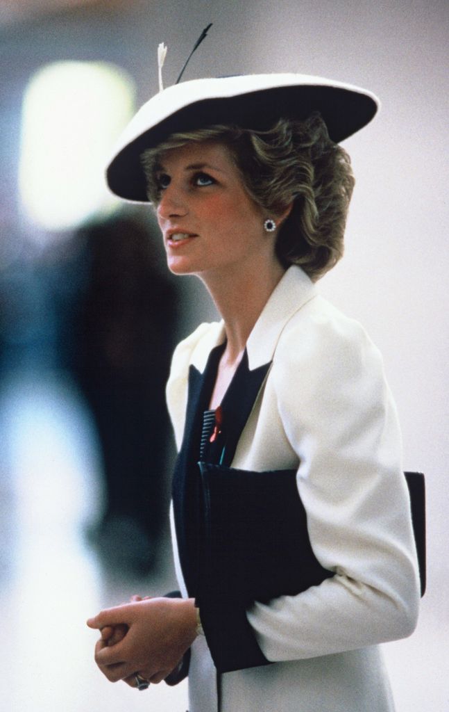 Diana in black and white suit and hat side profile