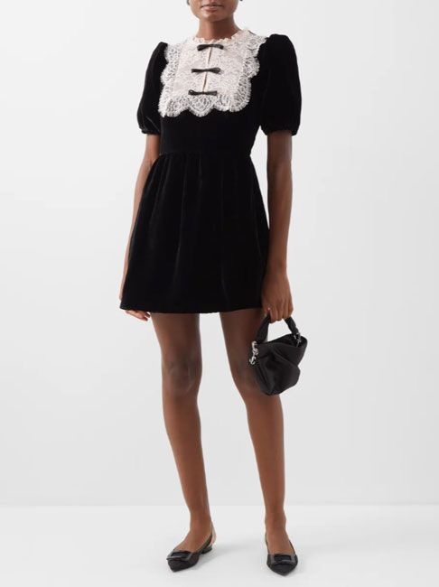 model wearing black mini dress with lace trim