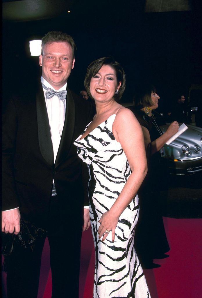 Henrik Brizen in a black suit standing with Jane McDonald in a zebra-striped dress