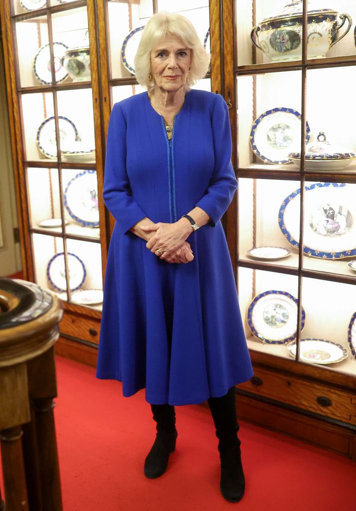 Camilla in knee-high boots and blue dress