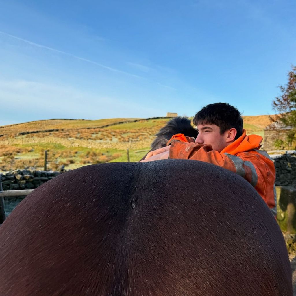 Amanda Owen's son Reuben leaning on a horse