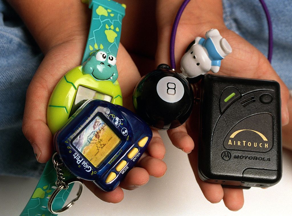 Un enfant tient de petits objets dans ses mains, notamment un porte-clés à huit balles, un porte-papier élastique Santio et un animal Giga.