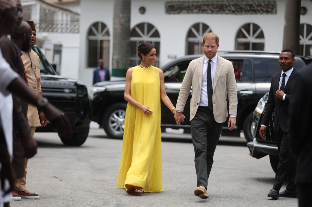 Britain's Meghan (L), Duchess of Sussex, and Britain's Prince Harry (R), Duke of Sussex arrive at the State Governor House in Lagos on May 12