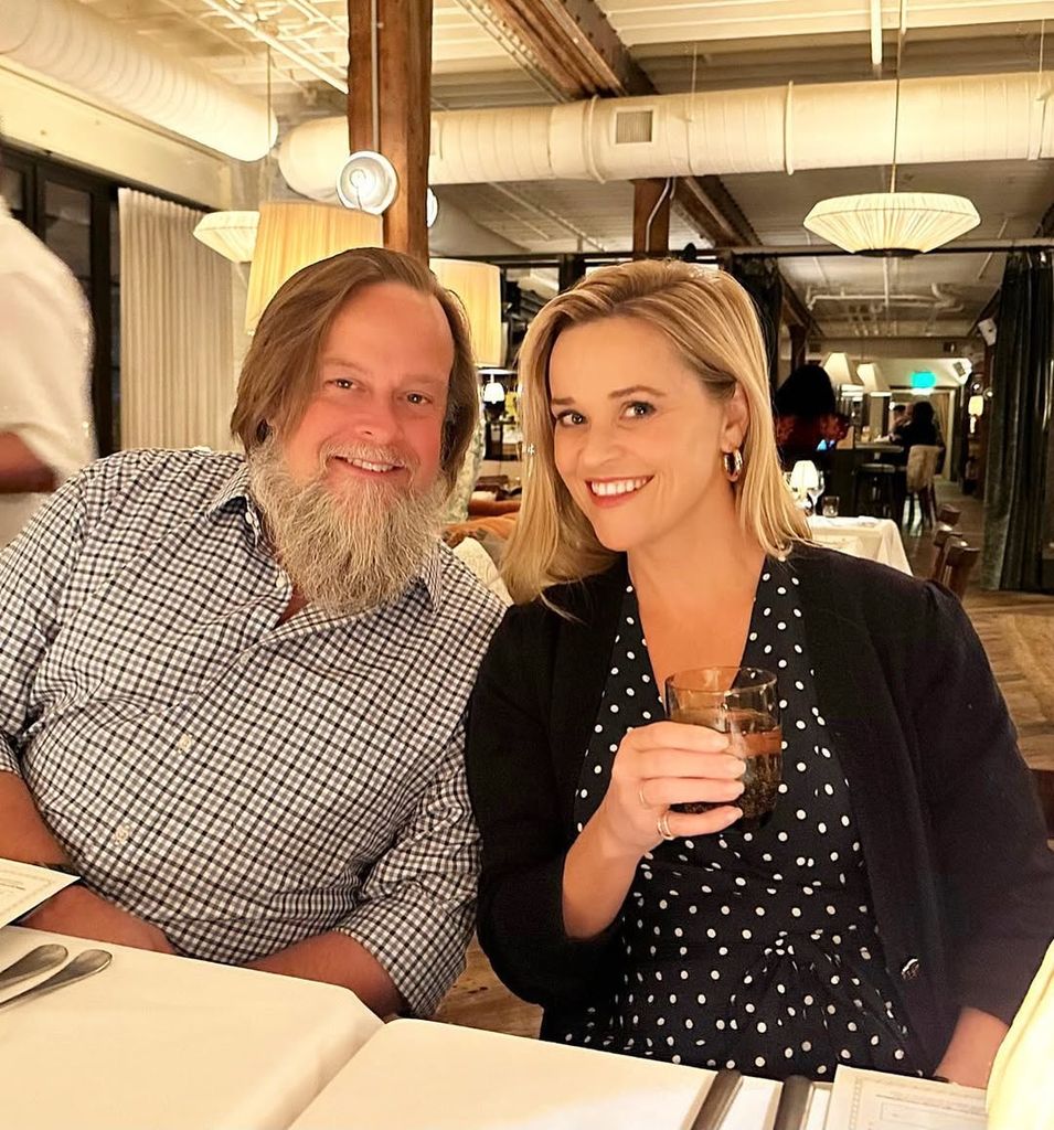 Reese Witherspoon and her brother posing for a photo in a restaurant