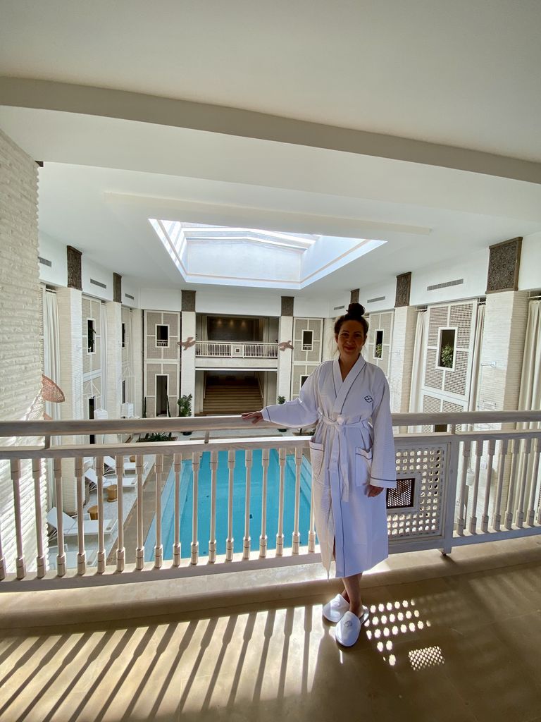 Woman standing on a balcony over a pool