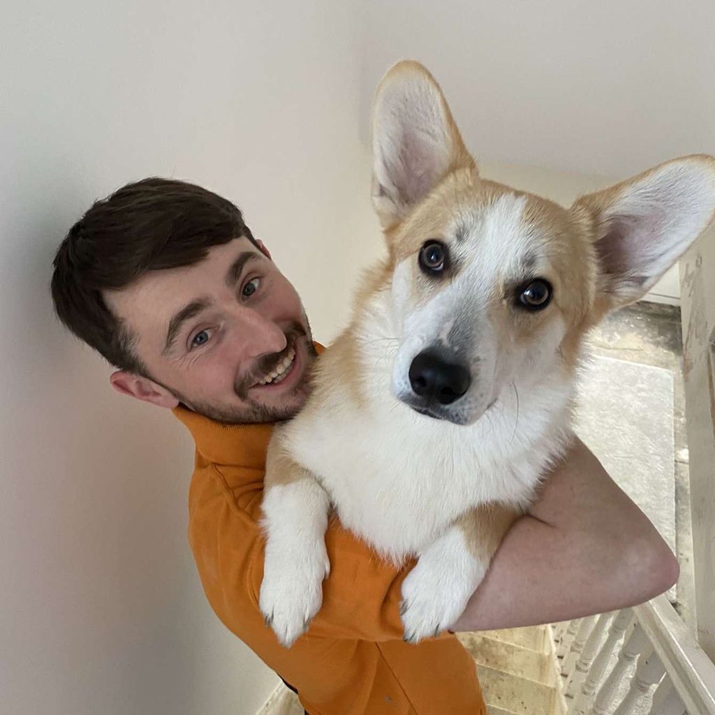 Pete Sandiford holding pet corgi at sister Sophie's home