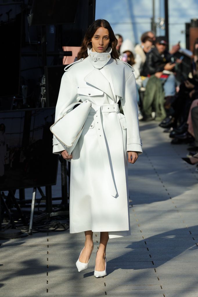 Model in white trench coat during Stella Mcartney show