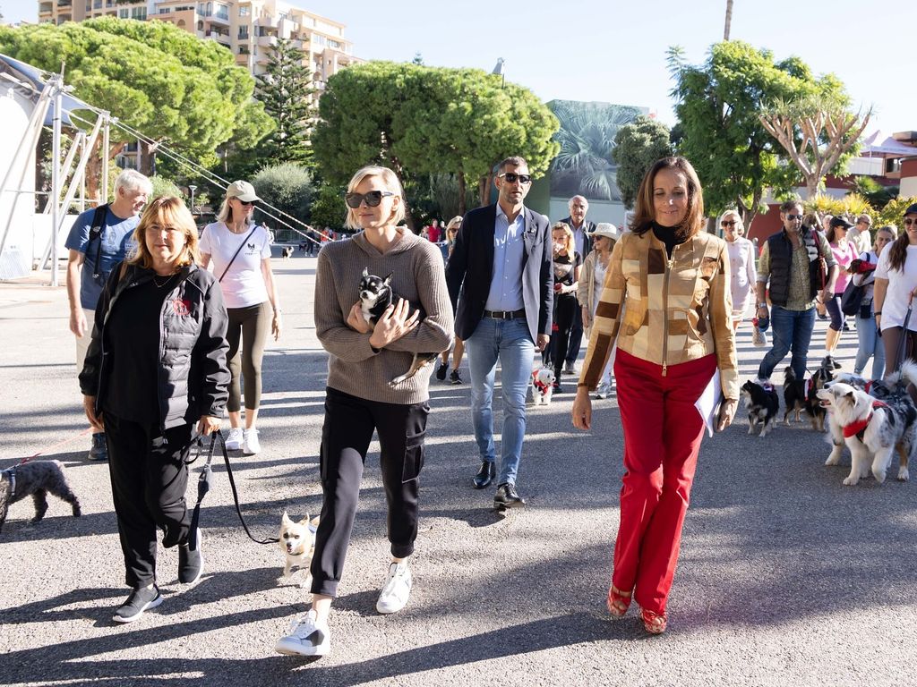 Princesa Charlene vestindo jogging andando segurando cachorro