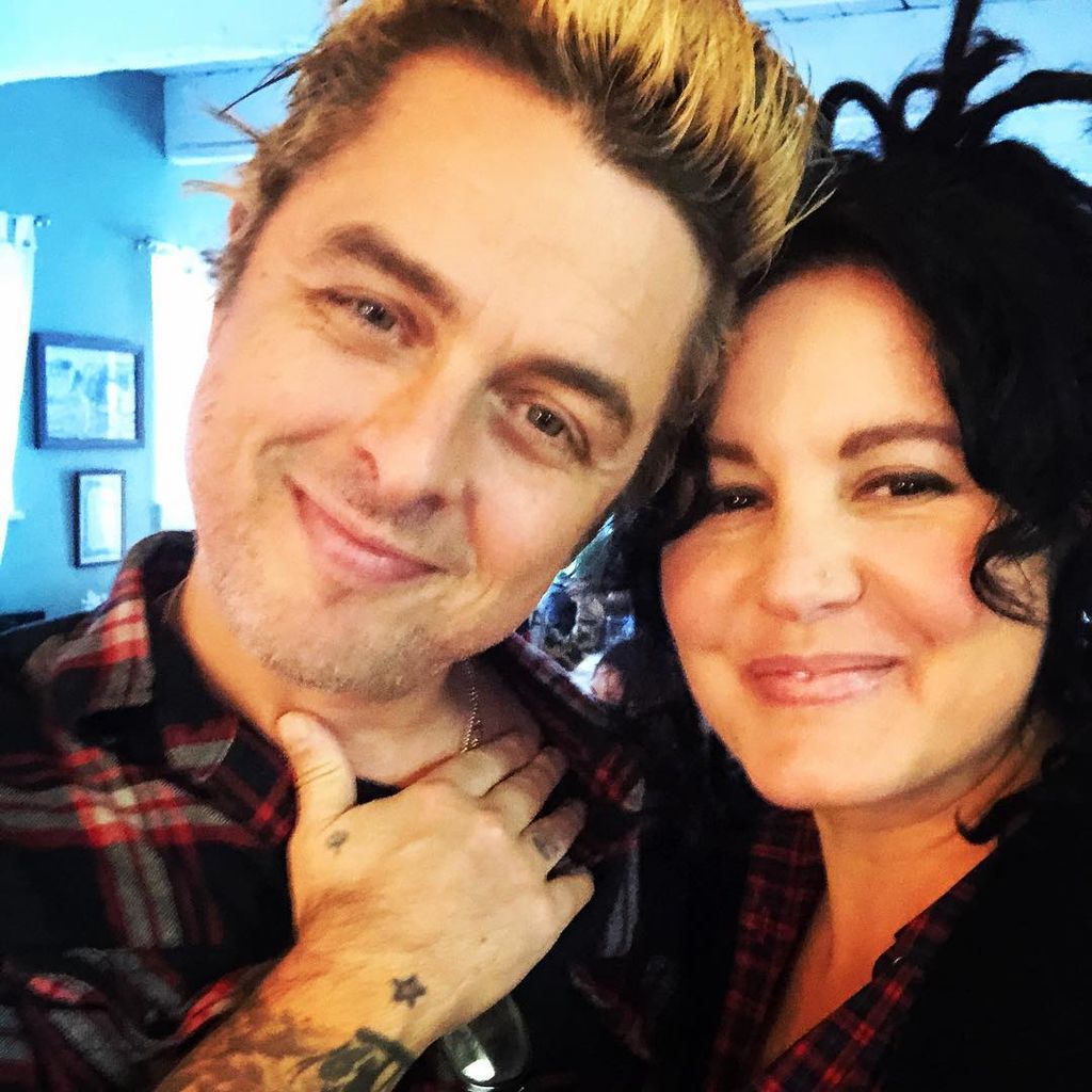 photo of billie joe armstrong smiling with head against wife adrienne