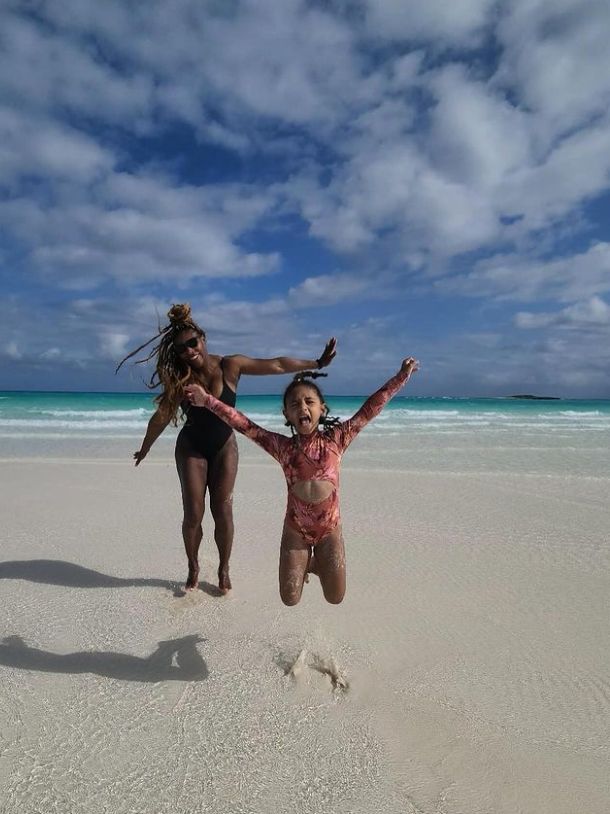 Serena Williams and a young girl on the beach, the young girl is jumping into the air
