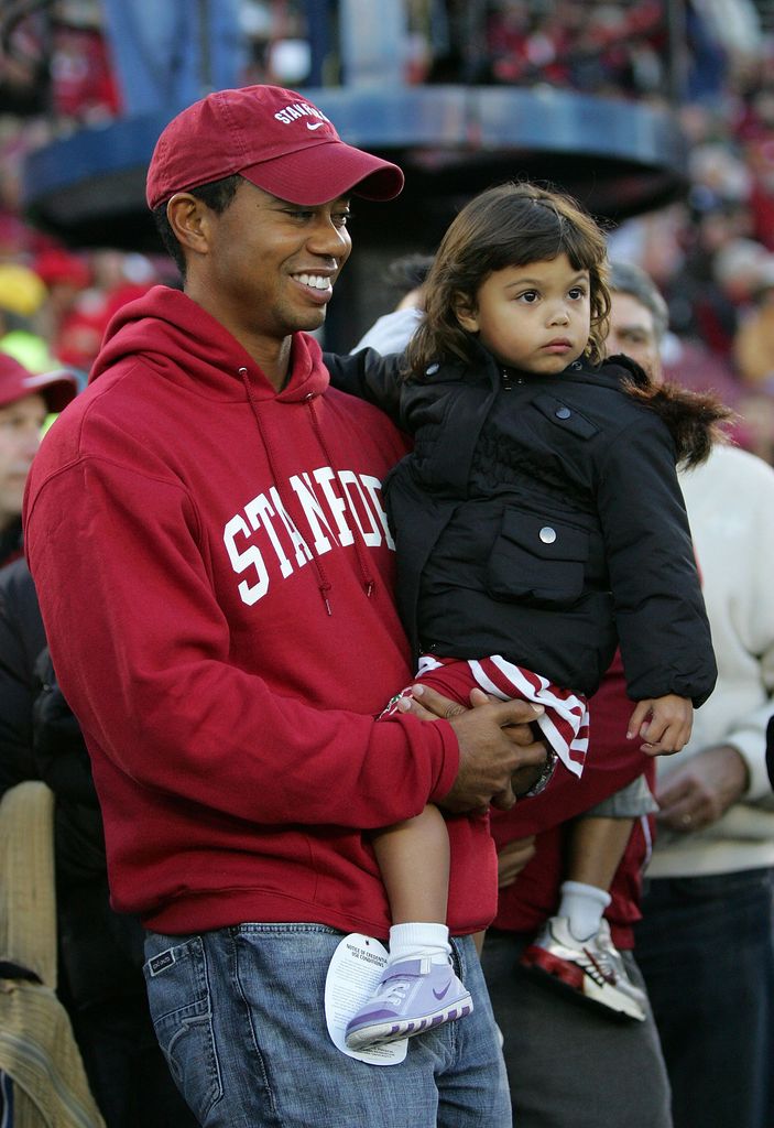 Honorary Standford Cardinal captain Tiger Woods holds his daugher, Sam, on the sidelines before the Cardinal game against the California Bears at Stanford Stadium on November 21, 2009 in Palo Alto, California.