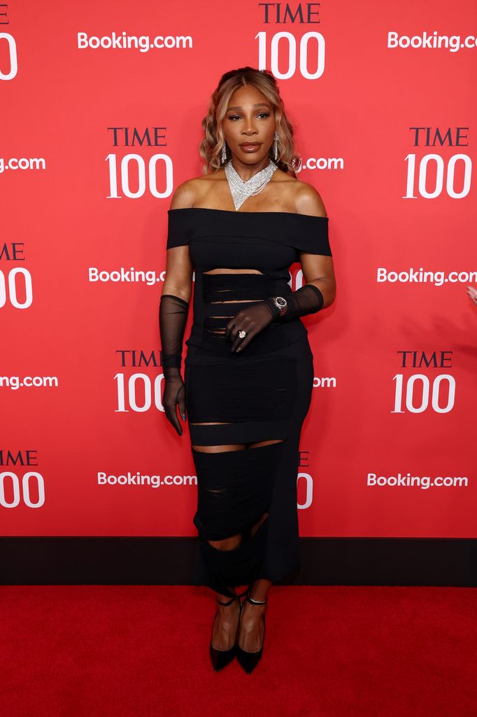 Serena Williams wears a black, cut out off the shoulder dress with black mesh gloves, black heels and a dramatically sparkling necklace. 