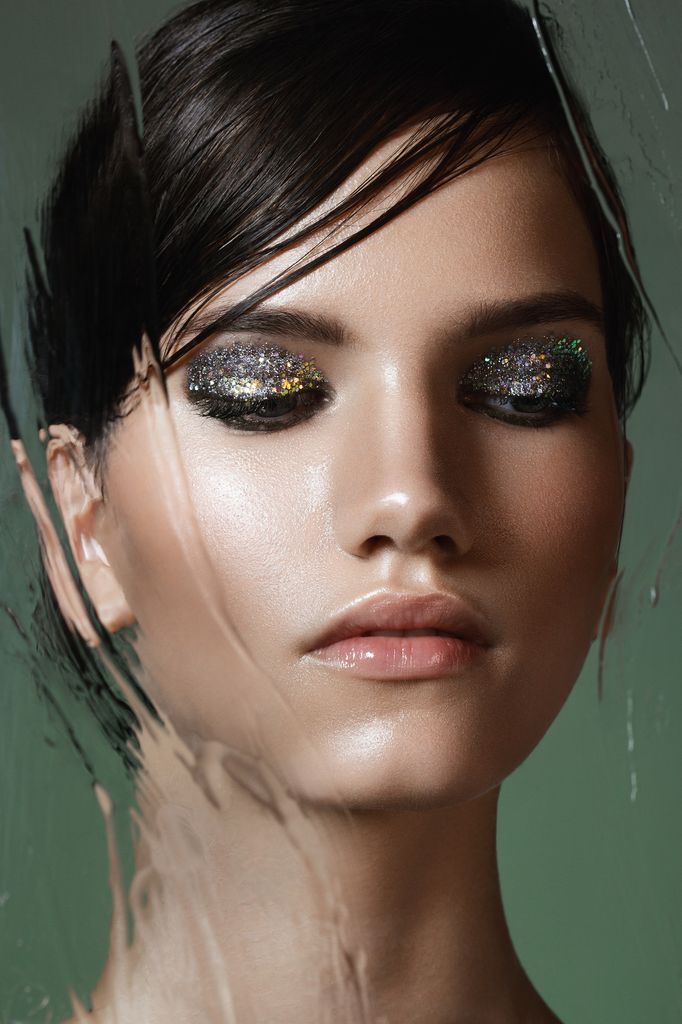 Beautiful woman behind wet glass