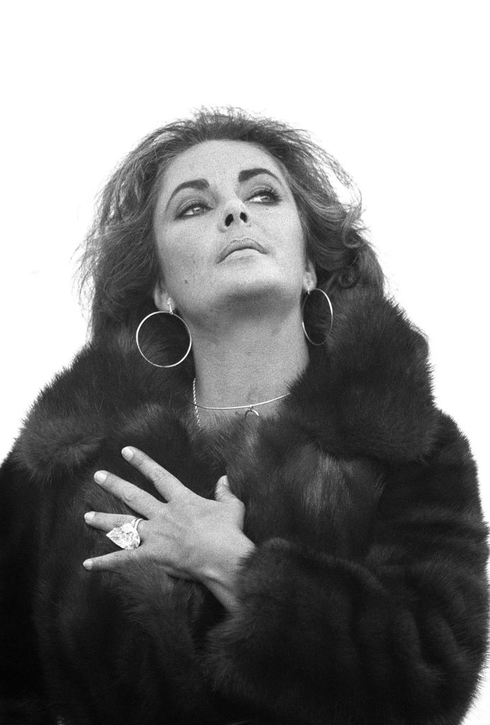Elizabeth Taylor showing huge diamond ring in fur coat