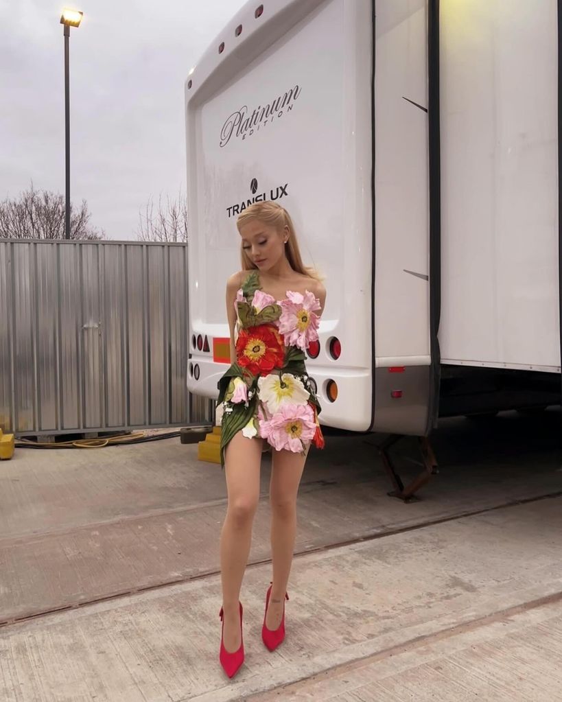 Ariana in front of trailer in floral mini dress 