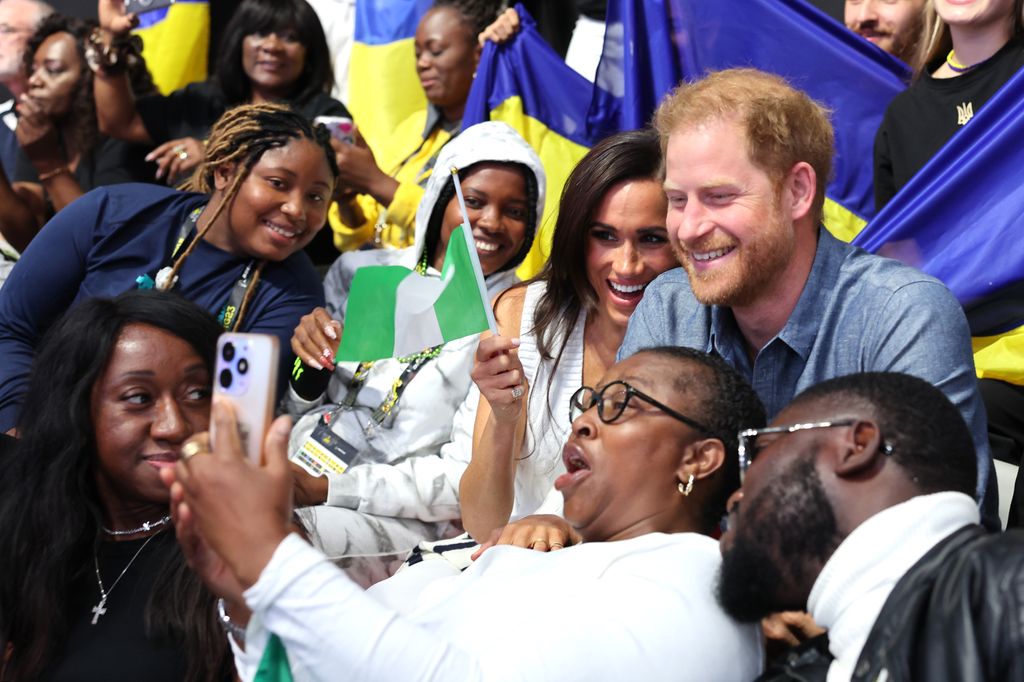 Prince Harry and Meghan take selfies with fans as they attend the Ukraine vs Nigeria volleyball