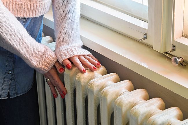 a woman touching the top of a radiator