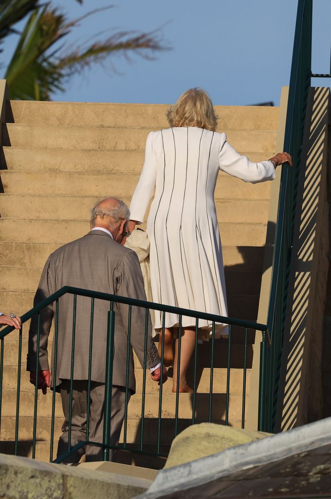 Camilla walked barefoot back up the steps, carrying her heels