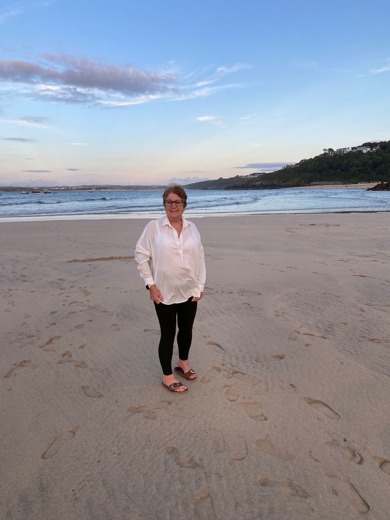 woman in white shirt and black leggings on the beach