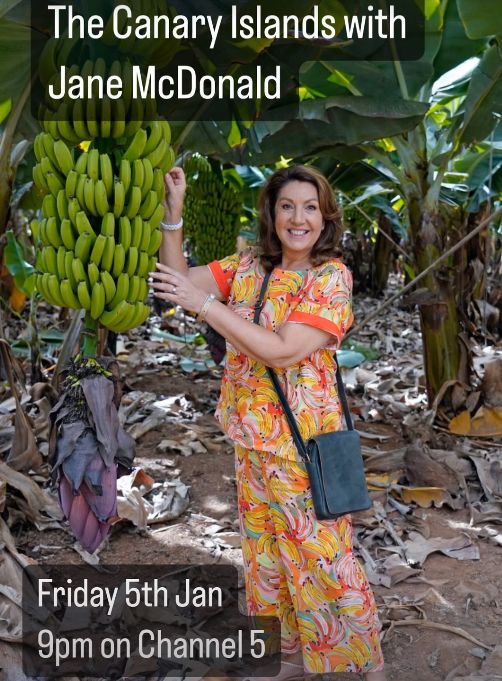 Jane McDonald em vestido estampado de banana em pé com bananas