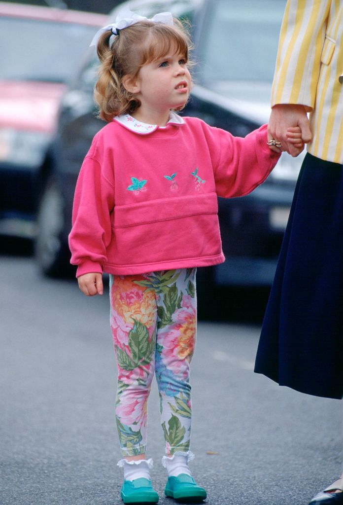 A photo of a four-year-old Princess Eugenie wearing floral leggings and a pink top