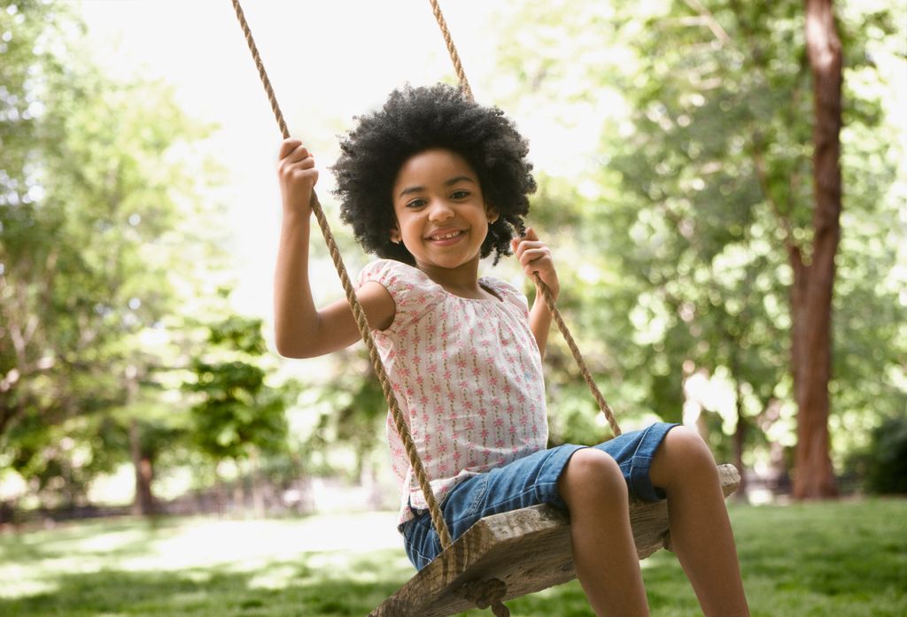 Child swinging in the garden