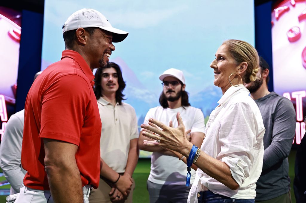 Tiger Woods of Jupiter Links Golf Club talks with singer Celine Dion after their TGL presented by SoFi match against the Atlanta Drive GC at SoFi Center on March 04, 2025 in Palm Beach Gardens, Florida