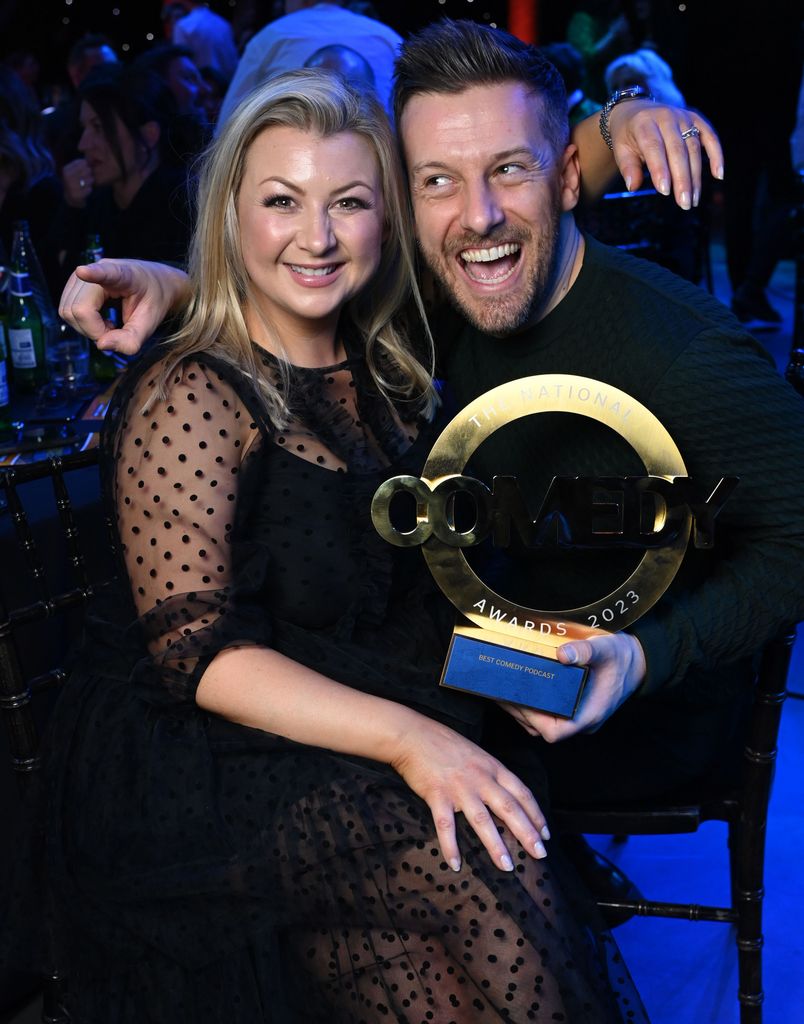 chris and rosie ramsey posing with podcast award