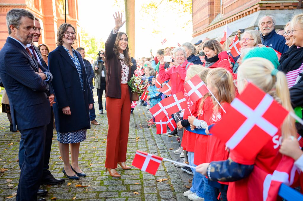 Queen Mary acenando ao lado do Ministro Presidente de Schleswig-Holstein Daniel Guenther e sua esposa Anke Guenther