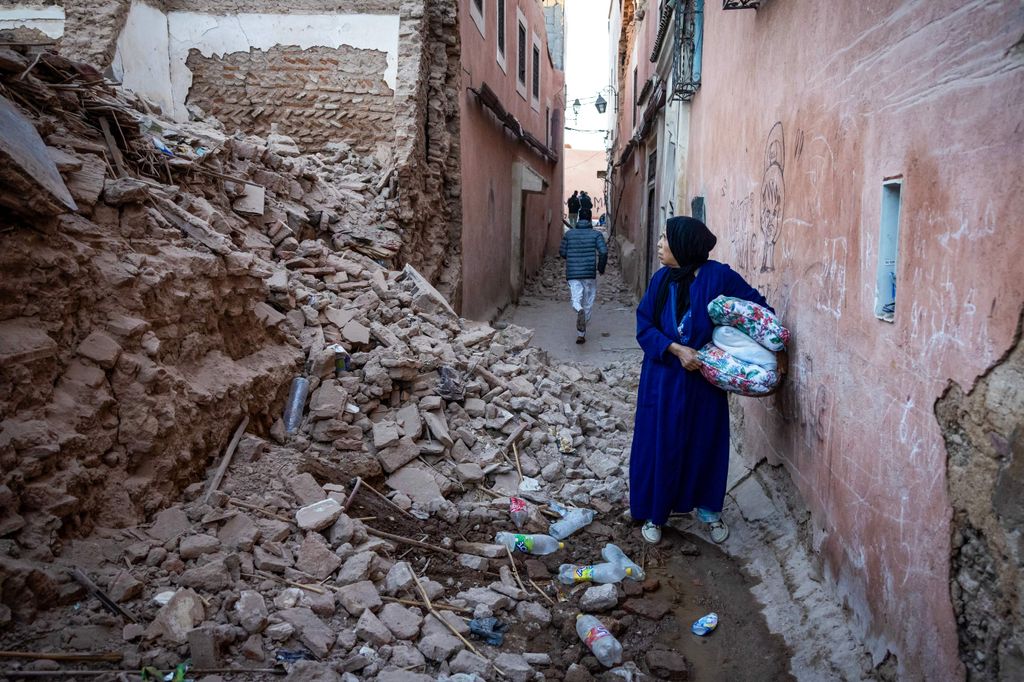 A woman looks at the rubble of a building in the earthquake-damaged old city in Marrakesh on September 9, 2023. A powerful earthquake that shook Morocco late September 8 killed more than 600 people, interior ministry figures showed, sending terrified residents fleeing their homes in the middle of the night.