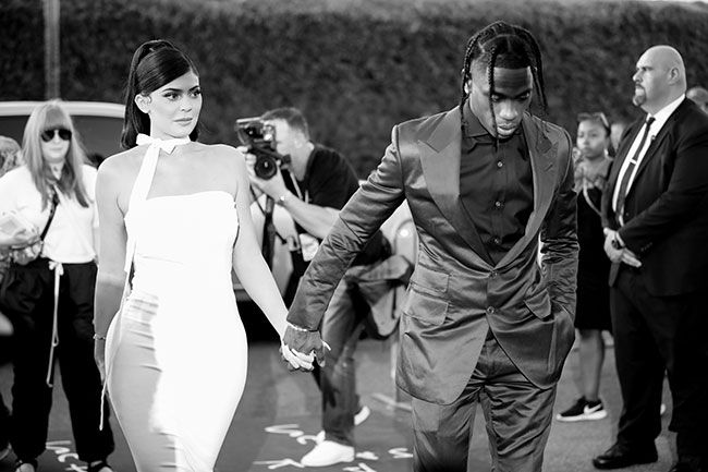 A black and white photo of Kylie and Travis holding hands