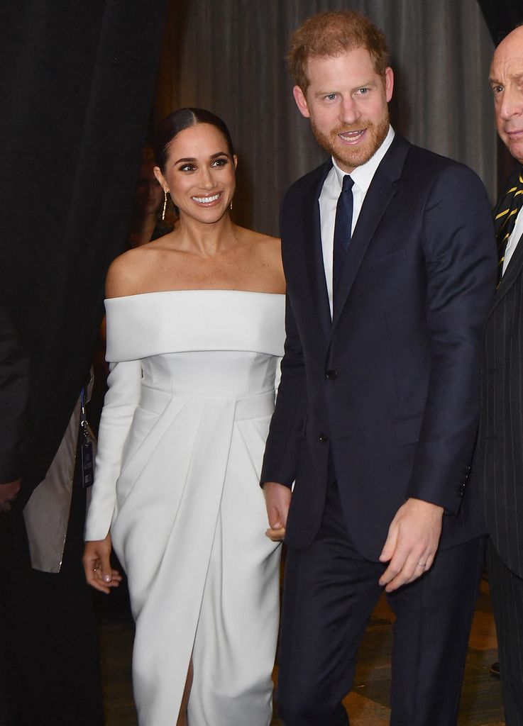Prince Harry and Meghan Markle smiling at gala event