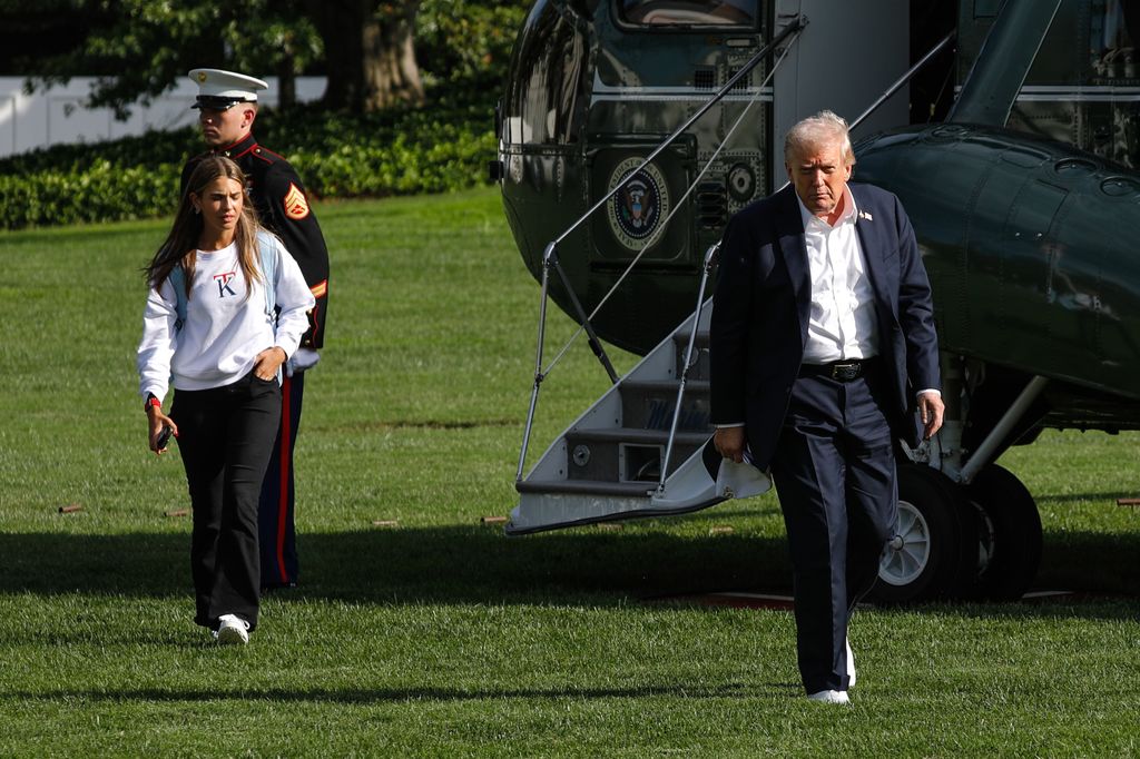 United States President Donald Trump and granddaughter Kai Trump walk on the South Lawn of the White House