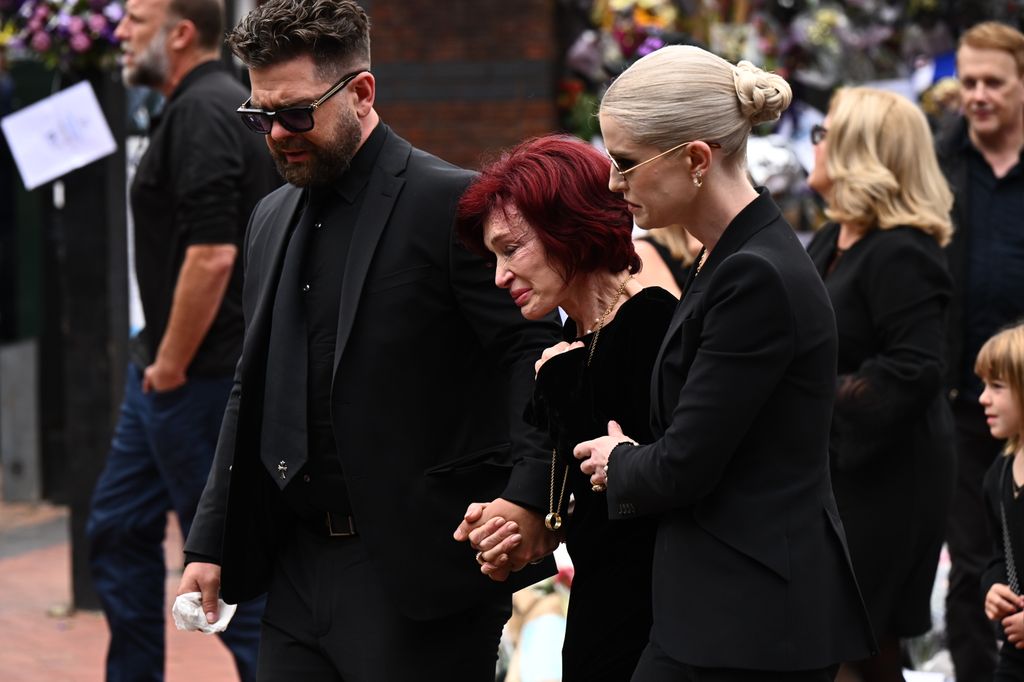 The family laid roses on top of the thousands of tributes before joining the procession once more to continue down Broad Street. 