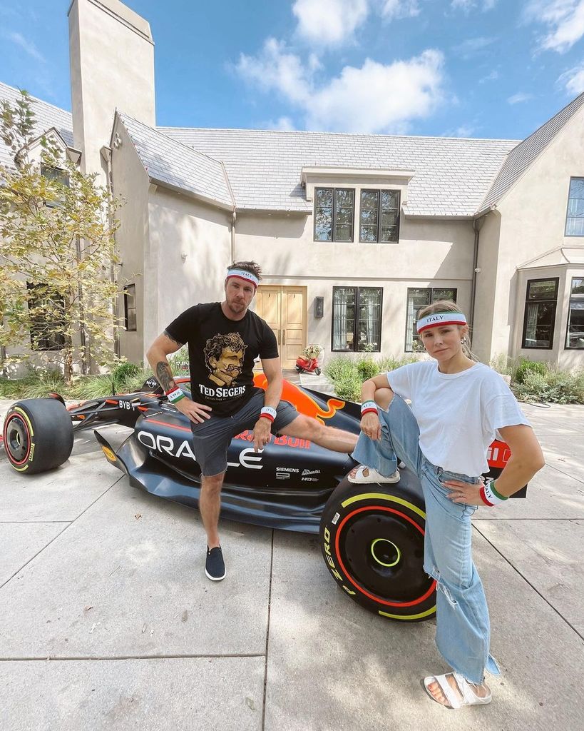 Dax and Kristen with F1 car outside their house in LA