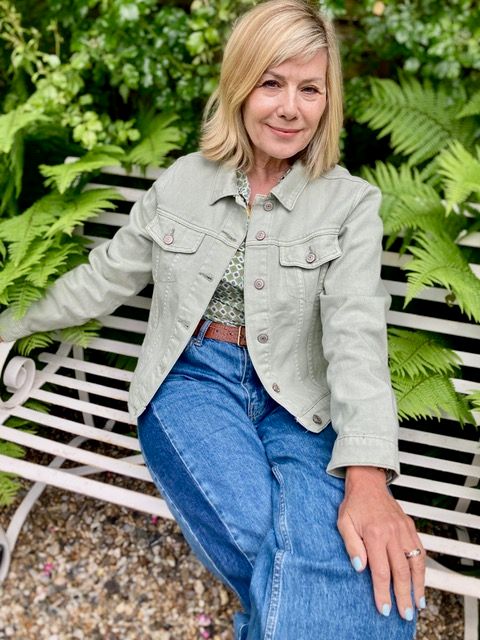 Glynis Barber está sentado en un banco con una chaqueta de mezclilla de un mezclilla azul