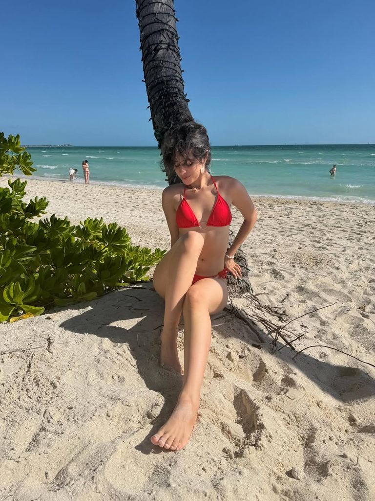 Camila Cabello grésille en bikini brûlant au milieu d'une évasion tropicale 1 Camila Cabello assise sur la plage en bikini rouge