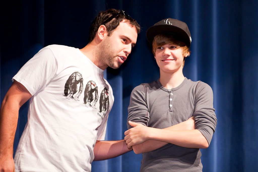 Justin Bieber talks with his manager before meeting with band camp students at Seminole High School in Sanford, Florida, on August 5, 2010. Bieber was on hand as part of a Best Buy and Grammy Foundation donation to the music program at Seminole High School