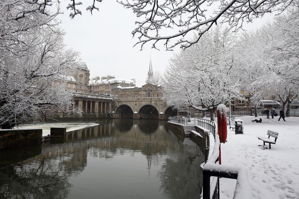 BATH, UNITED KINGDOM - JANUARY 18:  Snow covers trees besides Pulteney Bridge on January 18, 2013 in Bath, England. Heavy snow is bringing widespread disruption to many parts of the UK.  (Photo by Matt Cardy/Getty Images)