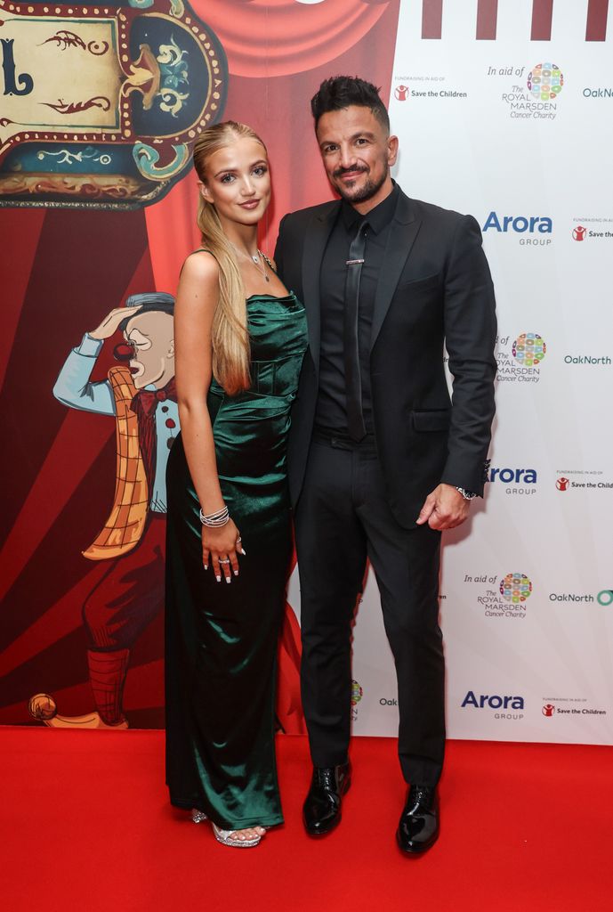 father and daughter posing on red carpet