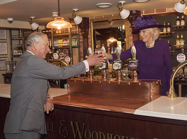Camilla, Duchess of Cornwall pours pint for Prince Charles in pub in Poundbury