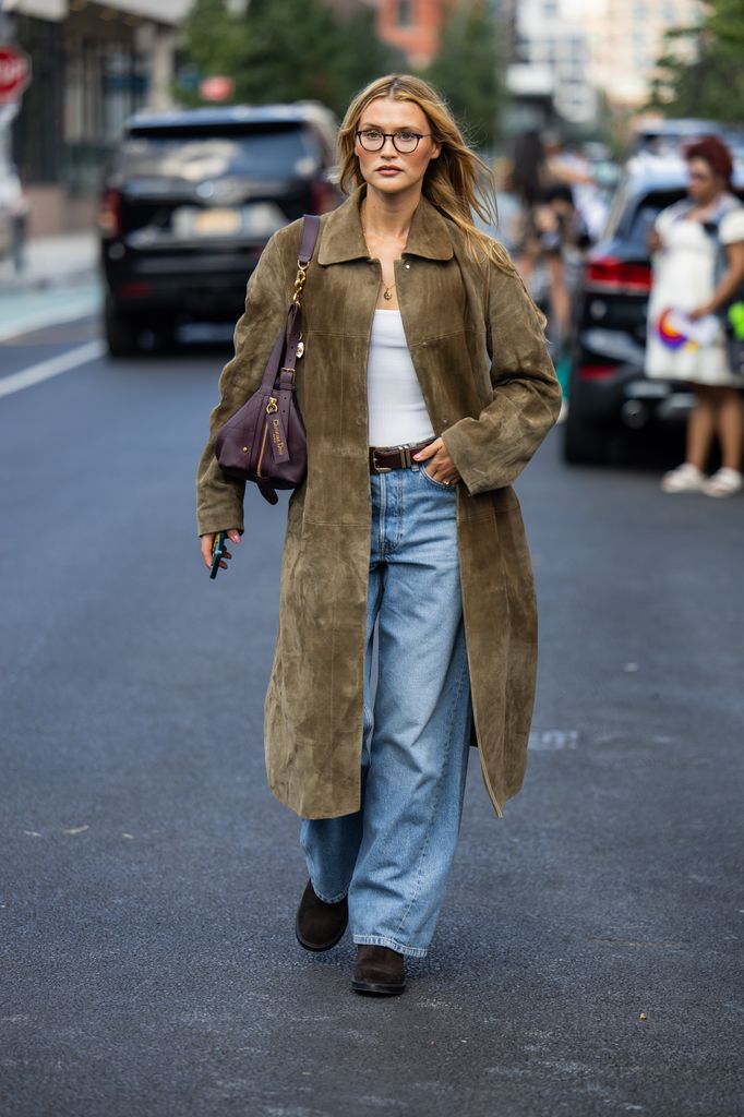  Chloe Lecareux wears khaki olive green suede coat, denim jeans outside Cos during New York Fashion Week on September 14, 2025 in New York City