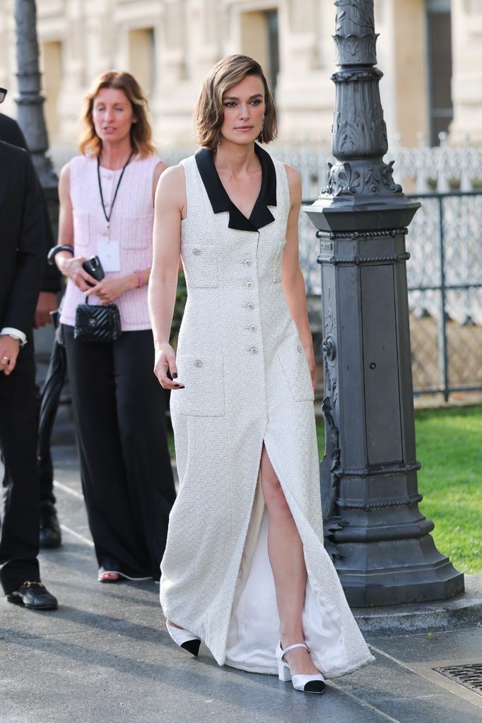 Keira Knightley walking in white leg split dress
