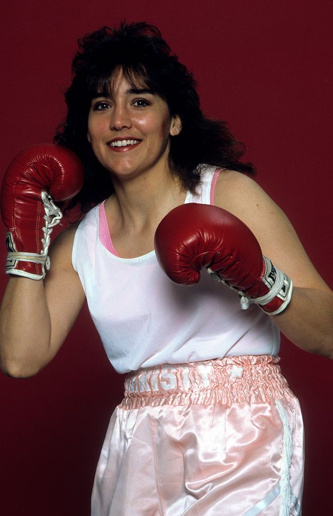 christy martin holding up fists in boxing gloves